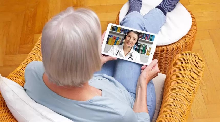 An elderly individual using a tablet for telehealth services.