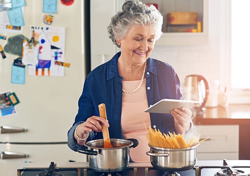 Elderly woman preparing a meal herself