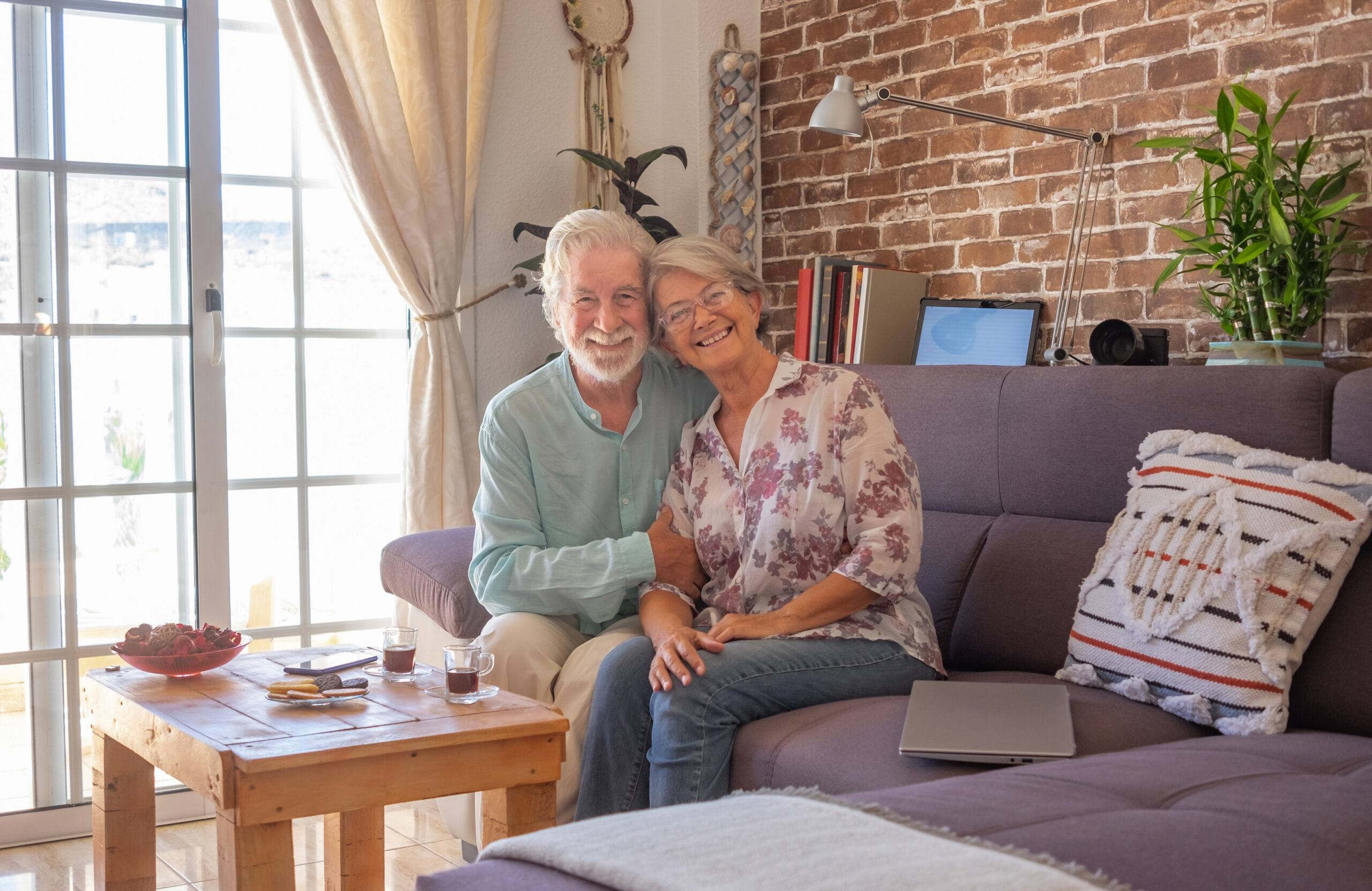 Happy senior couple on couch in living room. 